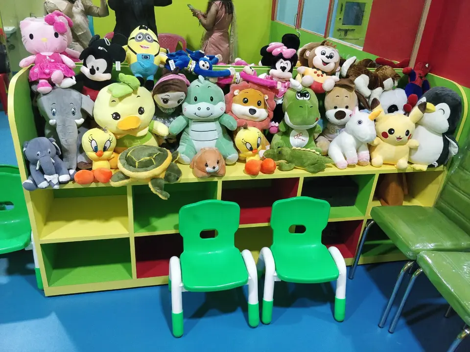 Toy corner with soft toys and child-sized green chairs at Cubs Gurukul